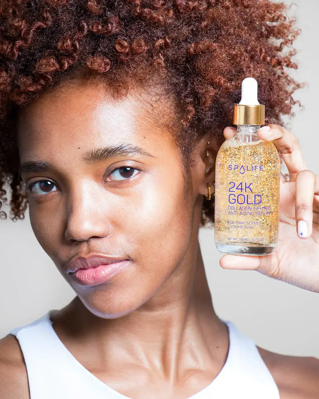 Sérum anti-âge infusé au collagène Gold 24K tenu par une femme à la peau éclatante. Fils collagène lifting coréen. Enrichi en or 24 carats, il hydrate et raffermit la peau.