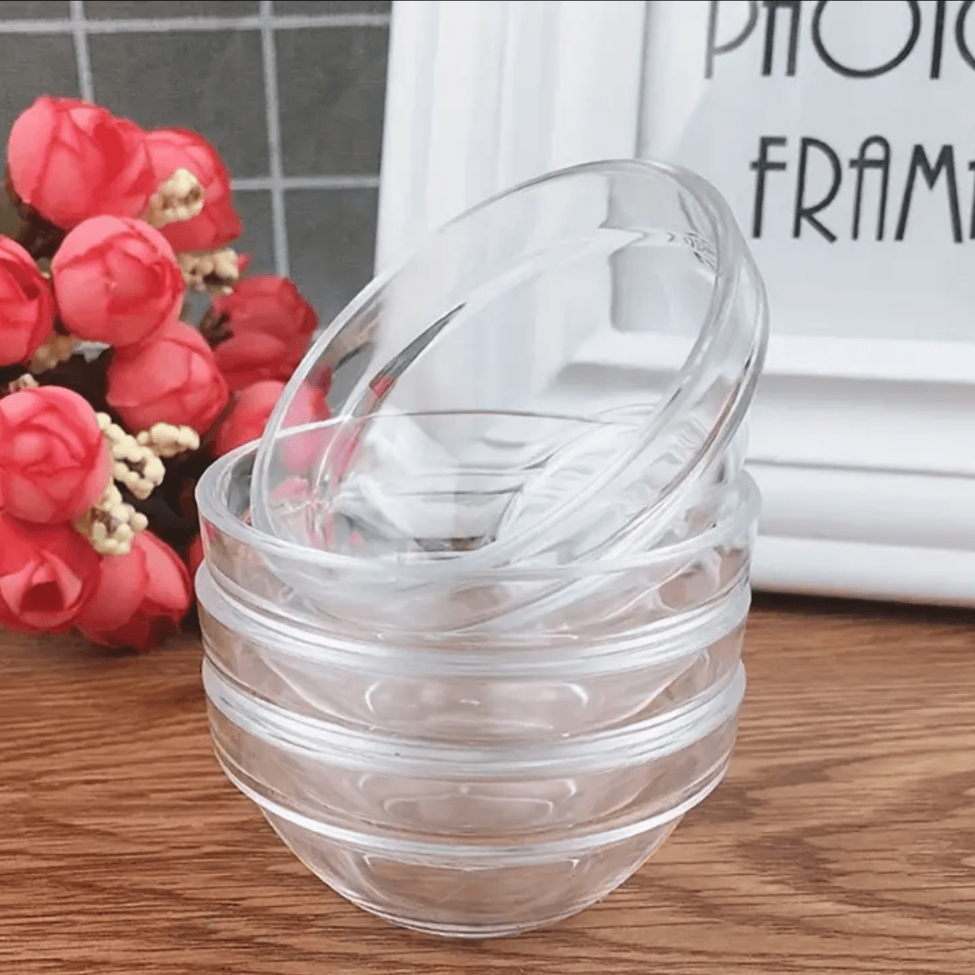Coupelles en plastique empilées sur une table en bois, parfaites pour les soins du visage. Accessoire essentiel pour doser crèmes et masques.