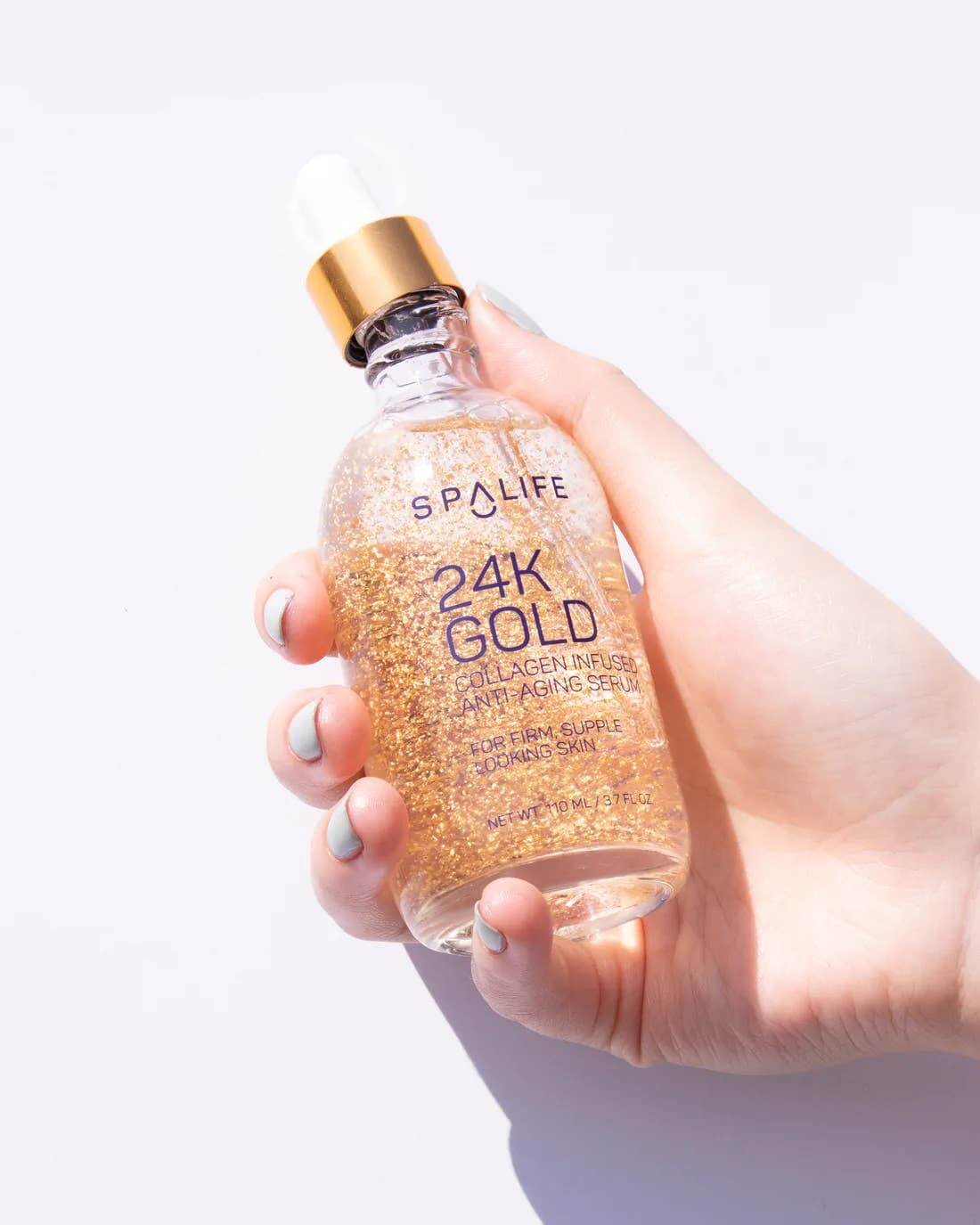 Duo Sérum Collagène + Fils de collagène, flacon de sérum avec or 24K pour la peau, main tenant le produit.