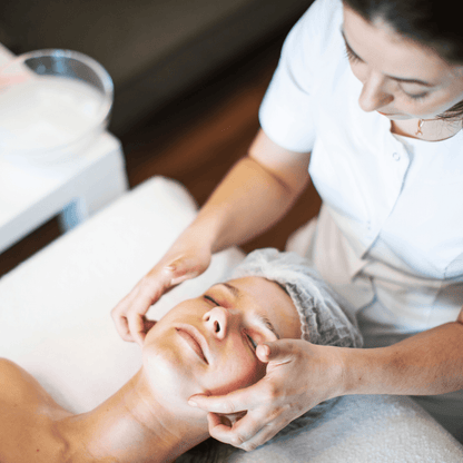 Esthéticienne réalisant un soin du visage avec le Kit Peeling Chimique sur une cliente relaxée.