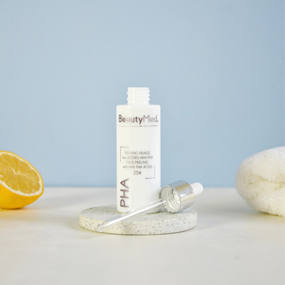 Peeling PHA 25 BeautyMed bottle with dropper on a stone surface next to lemon and towel.